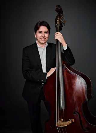 Pedro Gadelha é um homem branco, de cabelos castanhos. Ele está usando uma camisa branca e um paletó preto.