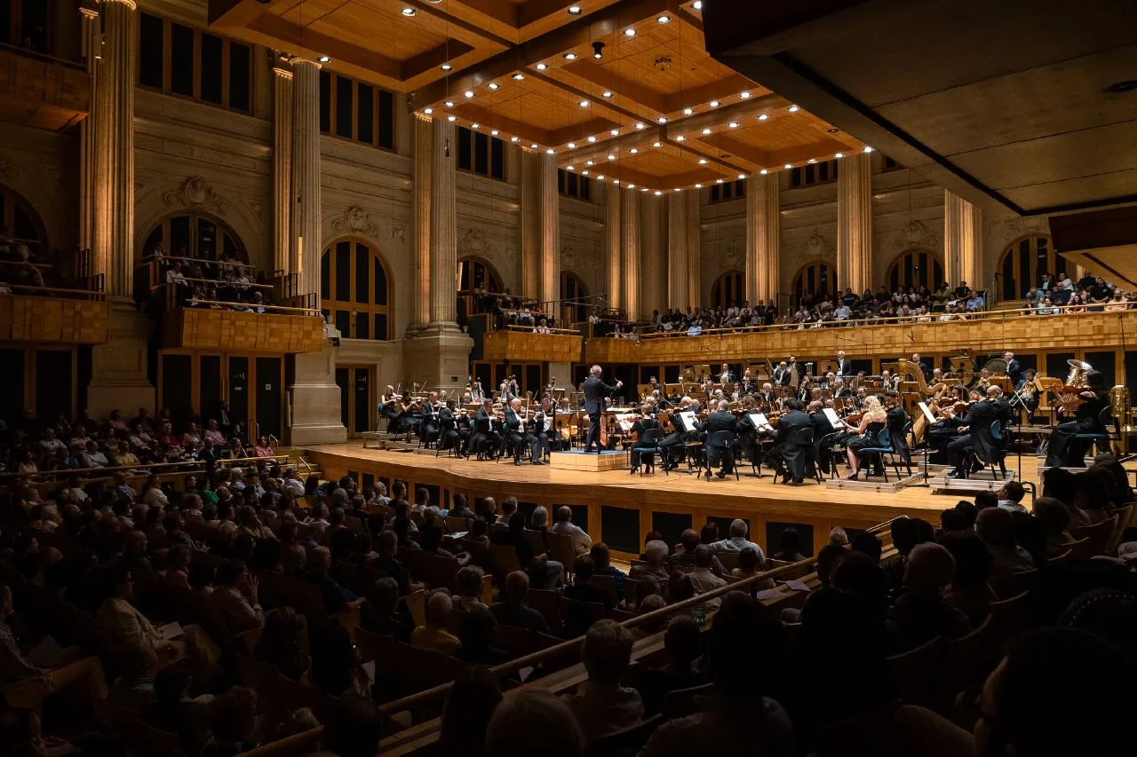 Foto do palco da Sala São Paulo, com músicos e integrantes do coro.
