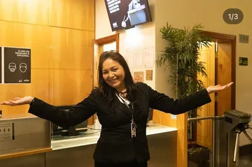 Maria Jocelma é uma mulher branca, de cabelos castanhos e longos. Ela está na entrada da Sala São Paulo.