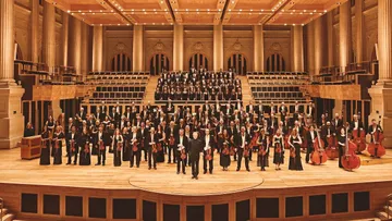 Foto do palco da Sala São Paulo, com músicos e integrantes do coro.